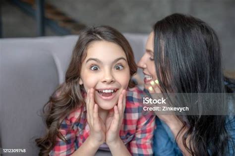 Darkhaired Mom Telling Something Interesting To Her Surprised Daughter
