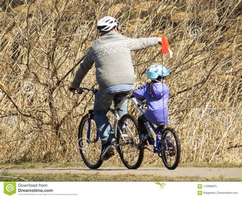 father and daughter riding bikes in the park editorial image image of