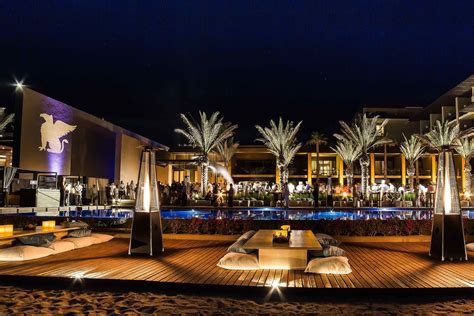 outdoor lounge area  night  palm trees  lit  buildings