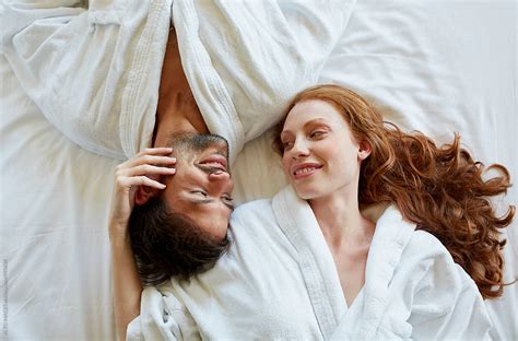 «romantic Couple Lying In Bed Of Hotel Room Del Colaborador De Stocksy