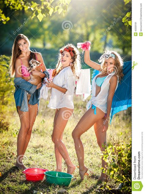 Tre Donne Sexy Con Le Attrezzature Provocatorie Che Mettono I Vestiti