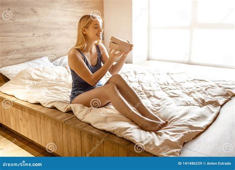 Young Beautiful Blonde Woman Sitting In Bed In Morning She Hold Box