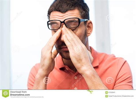 Tired Man In Eyeglasses Rubbing Eyes At Home Stock Image