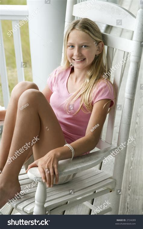 Caucasian Pre Teen Girl Sitting In Rocking Chair On Porch