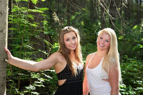 two girlfriends posing together in the woods in the sunshine edmonton