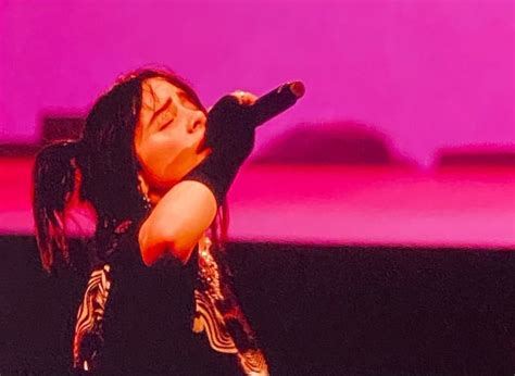 woman  long black hair holding  microphone    hand      sky