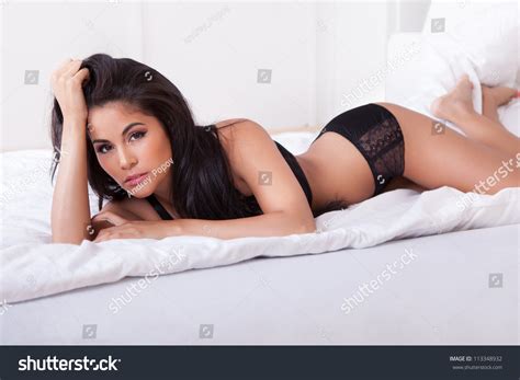 Beautiful Sexy Woman In Black Lingerie Lying On Her Stomach On Her Bed