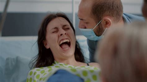 Close Up Of Pregnant Woman Pushing And Screaming In Hospital Ward At