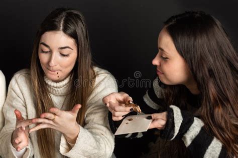 Girls Lick Their Fingers While Eating Chocolate Cream Desserts Stock