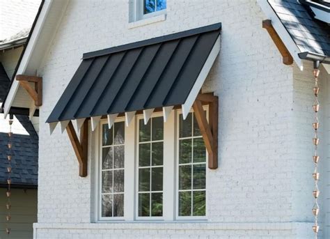 standing seam metal window awning cedar brackets exposed rafter tails rain chains  white
