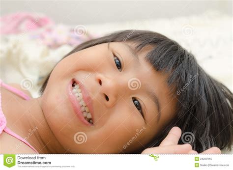 smiling asian girl lay down on bed stock image image of eyes teeth 24223115