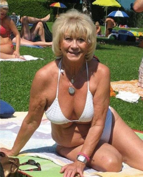 Mature Blond In White Bikini Top Laying On Blanket In Park
