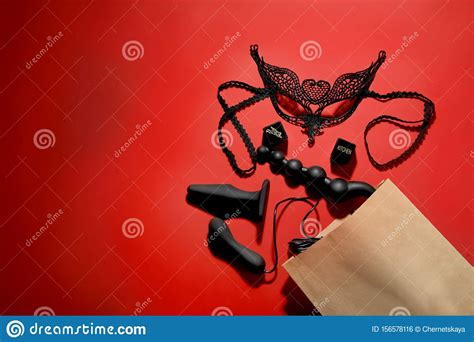 paper shopping bag with different sex toys on background