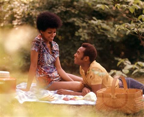 1970s romantic couple man woman picnic basket sitting grass african