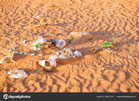 plastic waste bags packaging   rubbish trash abandoned   pristine sand desert
