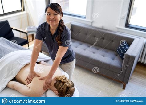chinese woman massage therapist giving a treatment to an attractive
