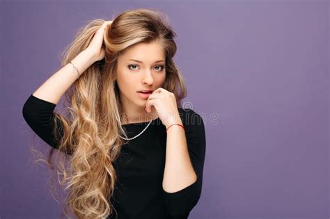 blonde sexy mooi meisje met het lange haar en glamourmake up stellen in