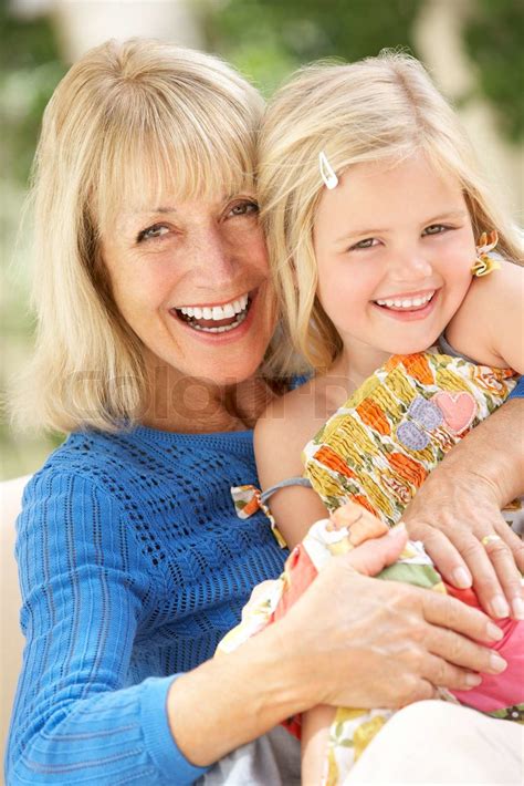 Grandmother And Granddaughter Relaxing On Sofa Together Stock Image
