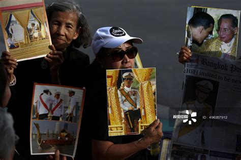 people hold up pictures of thailand s new king maha vajiralongkorn and late king bhumibol