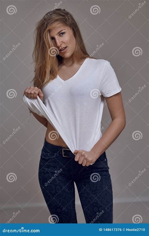 attraktive schlanke sexy junge blonde frau in den jeans und in einem
