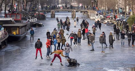europe weather amsterdams canals freeze  ice skaters flock