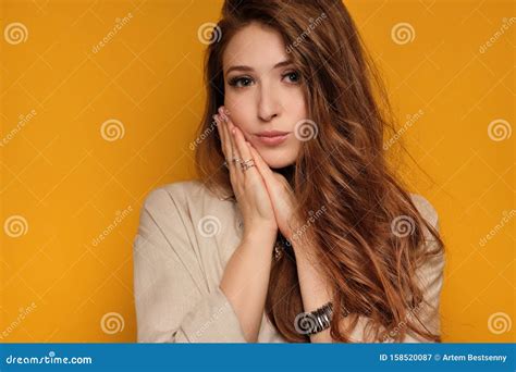Portrait Of A Redhead Girl Pressing Her Palm To Her Cheek And Looking