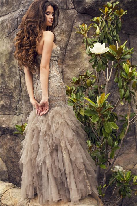 beautiful woman with long curly hair in luxurious dress
