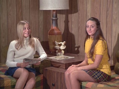 Two Women Sitting On Couches Talking To Each Other In A Room With Wood