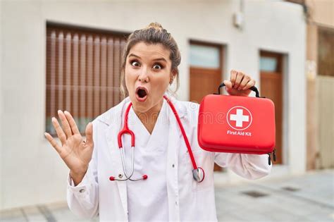 young doctor woman holding  aid kit scared  amazed  open