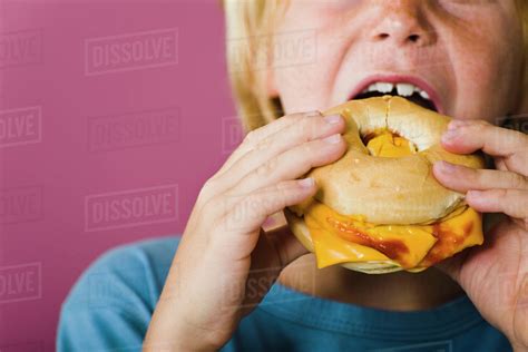 boy eating bagel  cheese sandwich cropped stock photo dissolve