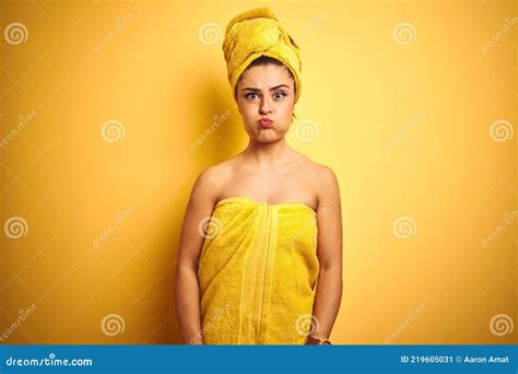 Young Beautiful Woman Wearing Towel After Shower Over Isolated Yellow
