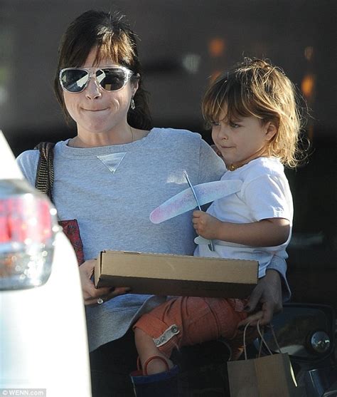 selma blair carries wo takeaways back to her car her son
