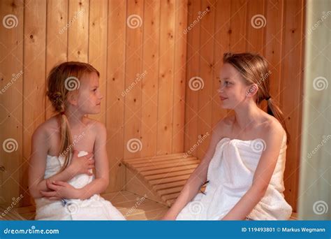 2 Girls Are Sitting In The Sauna And Looking At Each Other Stock Image
