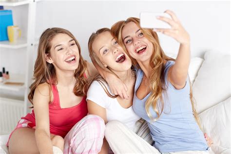 teen girls with smartphone taking selfie at home stock