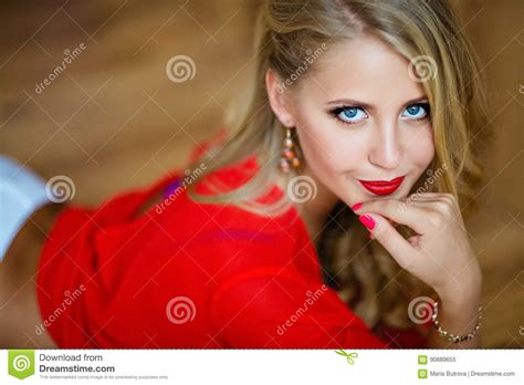 very beautiful blonde girl with blue eyes in red blouse