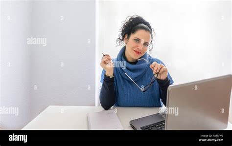 Normal Female Secretary Working In An Office With A Laptop Looking At