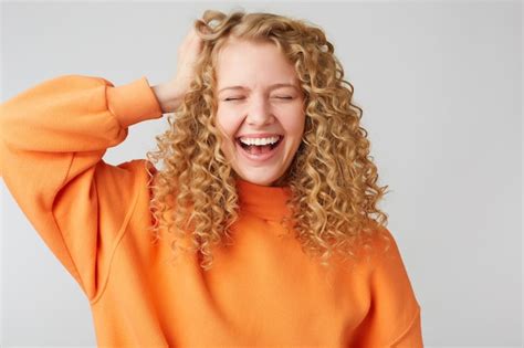 Free Photo Cheerful Carefree Joyful Curly Haired Blonde Holds Her