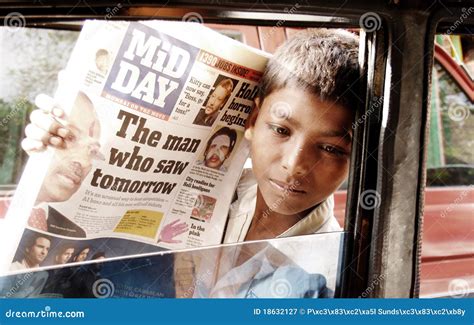 poor street boy  india selling newspapers editorial photography