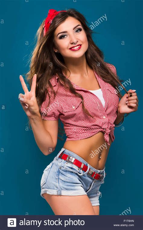 happy brunette pinup girl con piercing all ombelico indossa in vecchio stile camicia a scacchi