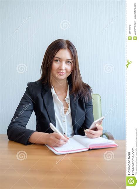 Secretary Talking On Mobile Phone And Writing Notes While