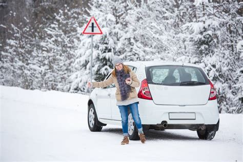 young woman hitchhiking   snow covered winter road stock photo image  tree europe