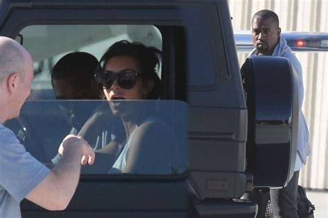 Kim Kardashian Plays The Doting Wife As She Collects Husband Kanye West
