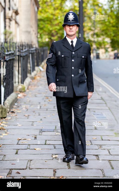 smartly dressed english policeman  full uniform patrolling