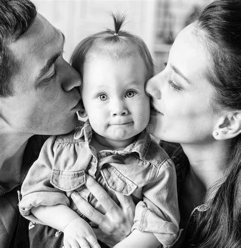 Bw Portrait Of Mother And Father Kissing His Year Old Daughter Stock