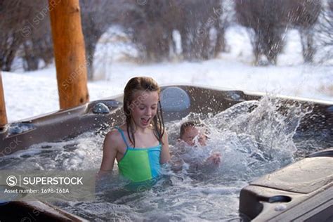 Girl In A Hot Tub With Her Brother Splashing Water Superstock