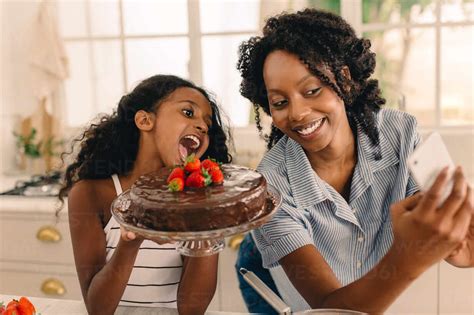 Beautiful Mother With Cute Girl Taking Selfie Holding A Chocolate Cake