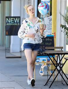 elle fanning looks spring chic in tropical print blouse and denim shorts as she steps out to