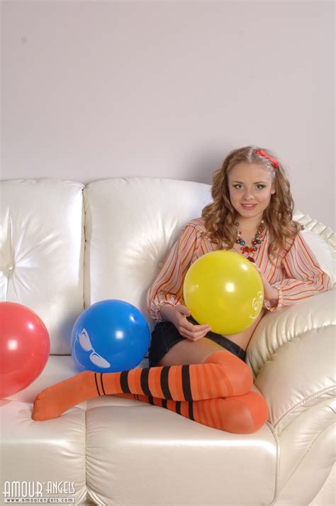 beautiful shapely teen honey with colorful balloons taking off her clothes on the sofa
