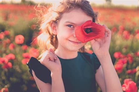 beautiful girl in poppy field enjoys the beauty and aromas stock image