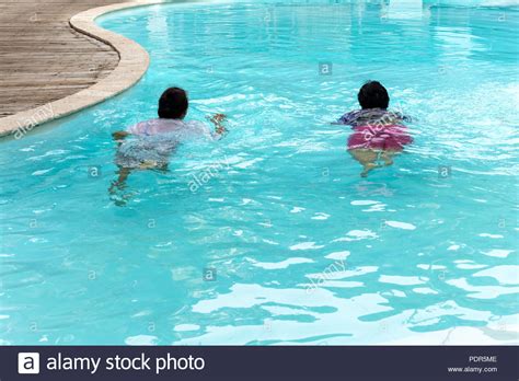 Two Senior Women Doing Aqua Gym Exercise In Outdoor Swimming Pool Stock